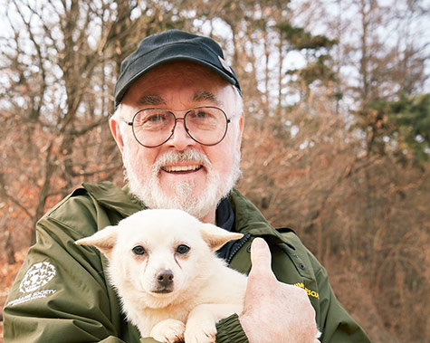 Peter Egan,hold a Dog resuce from Dog meat farm at South Korea, humane society international ,Korea,Photographer,Manchul Kim